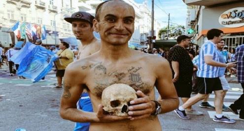 مشجع يحتفل مع "جمجمة جده" بتتويج ريسينج بالدوري الأرجنتيني